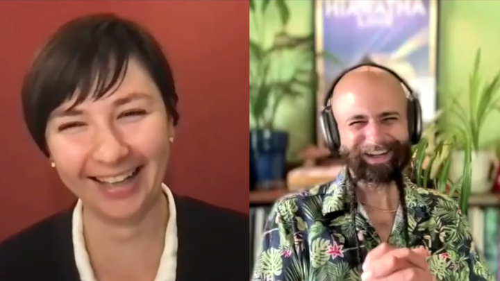 Screenshot of two people on a video call, a dark-haired white woman and a bald white man with a dark beard. Both o laughing.